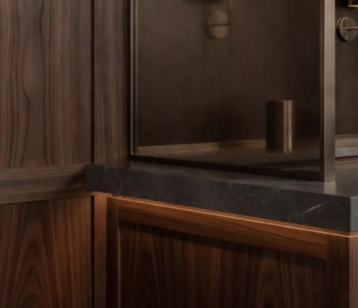 Detail of dark walnut wood and brushed bronze interior finishes in a boutique poker lounge